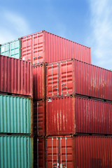 Fototapeta premium Forklift truck lifting cargo container in shipping yard or dock yard against sunrise sky with cargo container stack in background for transportation import,export and logistic industrial concept