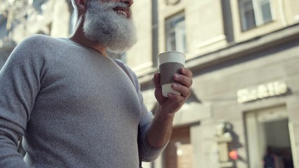 Scaled up look on bearded man enjoying cup of coffee