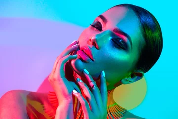 Foto auf Acrylglas Mode-Modell-Frau in bunten hellen Lichtern posiert im Studio, Porträt eines schönen sexy Mädchens mit trendigem Make-up und Maniküre © Subbotina Anna