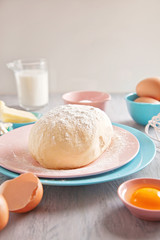 Baking ingredients and dough on wooden background