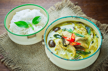Thai food green curry chicken on wooden background.