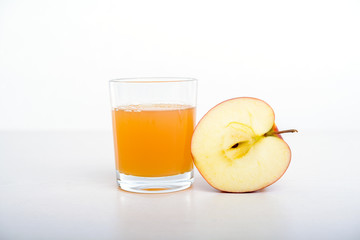 half apple with glass of naturally cloudy juice