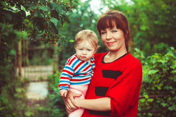 Fototapeta premium Mum the child on hands greens
