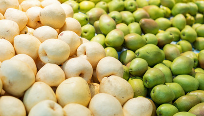 Bunch of green pears on boxes in supermarket