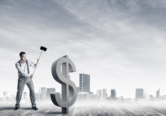 Determined banker man against modern cityscape breaking dollar c