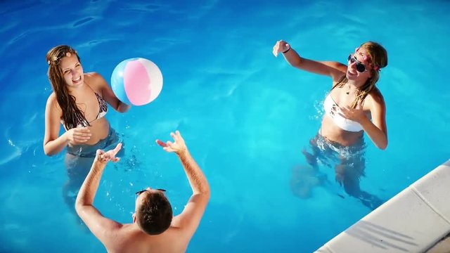 Friends playing ball games in pool