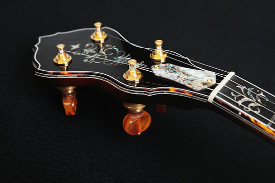 Mahogany banjo luxury gold inlaid with mother of pearl on a black background
