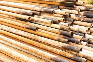 Steel tubes against industrial blurred background