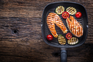 Salmon. Grilled fish salmon. Grilled  salmon steak in grill pan on rustic wooden table