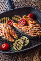 Salmon. Grilled fish salmon. Grilled  salmon steak in grill pan on rustic wooden table