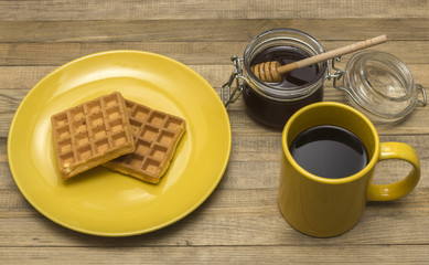 Viennese waffles with mug coffee and jar honey