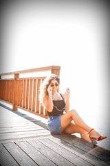 Girl on pier listening music with mobile phone