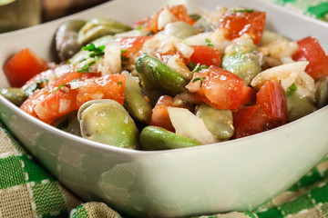 Broad bean salad with tomatoes, onion and olive