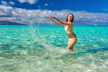 Young smiling woman having fun on the tropical beach - obrazy, fototapety, plakaty