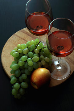 Glasses with pink wine and fruit..