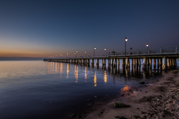 Obraz premium Amazing sunrise on the pier at the seaside. Gdynia Orlowo, Poland