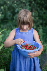 Kid with bowl red berries,  natural products