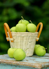 Homemade rustic green apples in a basket on an old stool.