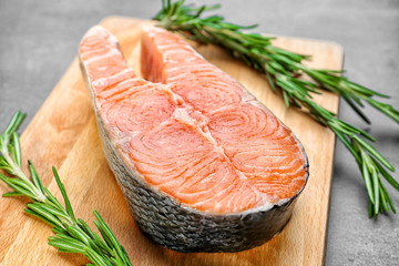 Fresh salmon steak with rosemary on wooden board