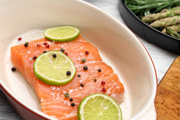 Fresh salmon fillet with peppers mix and lime in baking dish