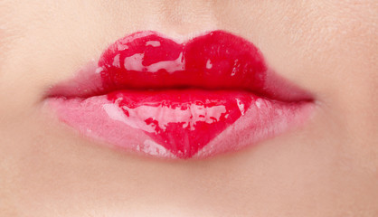 Obraz premium Heart painted with gloss on female lips, closeup