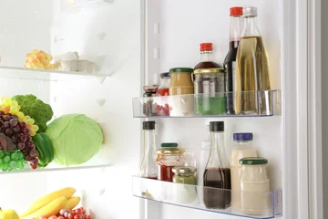 Gordijnen Different sauces on shelves in fridge © Africa Studio