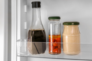 Different sauces on shelf in fridge