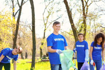 Group of young volunteers in park on sunny day