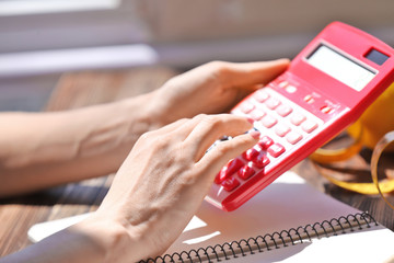 Obraz premium Young woman calculating calories at table. Weight loss concept