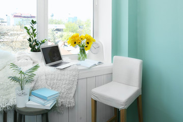 Modern comfortable workplace with laptop on window sill at home