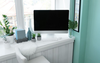 Modern comfortable workplace with computer on window sill at home
