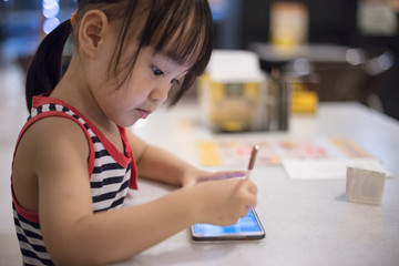 Asian Chinese little girl playing smartphone