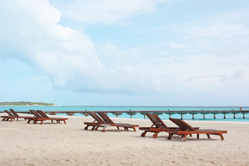 Obraz na płótnie Canvas Sun loungers on beach at sea resort