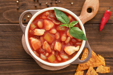 Casserole with delicious turkey chili on wooden table
