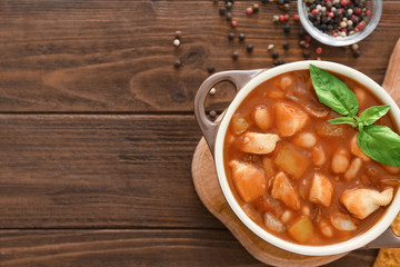 Casserole with delicious turkey chili on wooden table