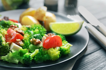 Plate with broccoli salad on table