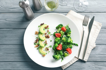 Plate with broccoli salad on wooden background