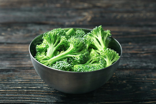 Bowl with fresh green broccoli on table