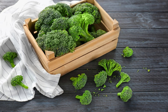 Wooden crate with fresh green broccoli on table