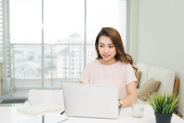 Happy businesswoman using laptop at workplace in office