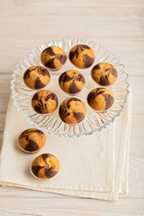 Muffins on a plate on light wooden background.