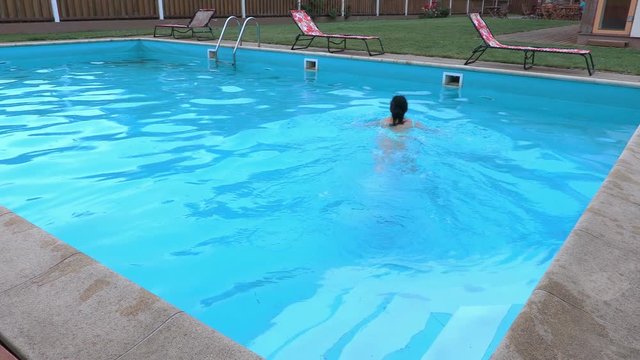 Woman begins to swim in the pool