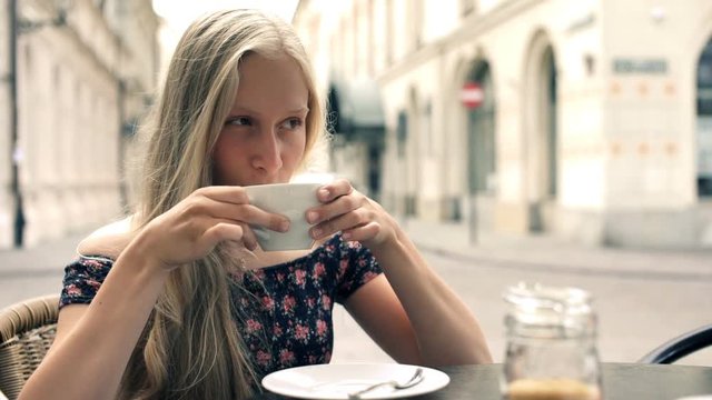 Young beautiful woman enjoing coffee in cafe in the city
