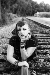 Junge Punk-Frau liegt auf Schienen