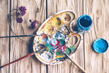 Dried flower near the palette with paints