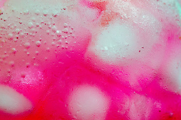 Close up photo of Light red or pink Italian soda in glass bottle with small bubble, Italian soda is...