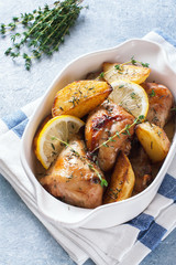 Chicken drumsticks baked with potatoes , lemon and herbs
