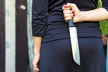 Woman in black holding a knife
