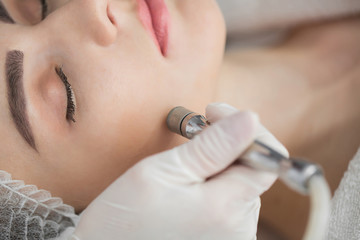 Diamond microdermabrasion, peeling cosmetic. woman during a microdermabrasion treatment in beauty...
