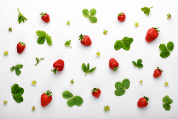 Fruit pattern made of fresh strawberry and green leaves on white background. Flat lay, top view.